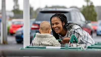 Woman and young toddler in shopping trolley